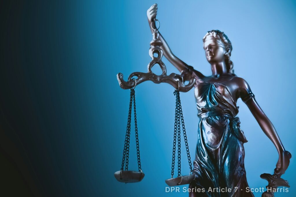 Statue of Lady Justice holding scales against a blue background