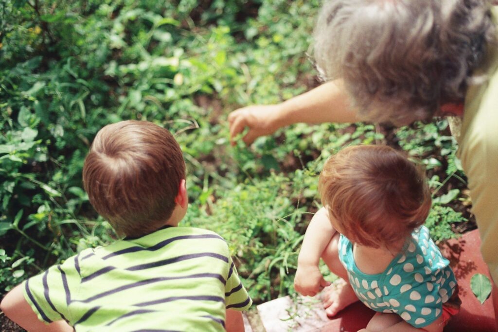 A woman exploring the garden with two children