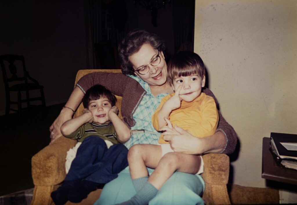 A 1960s snapshot of a mother in an armchair with her two children