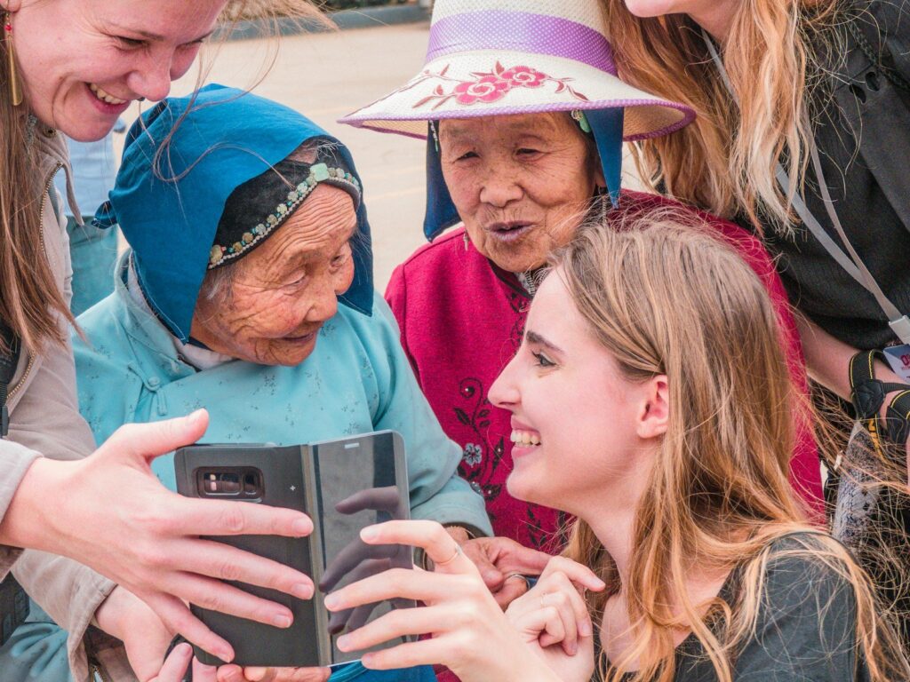 A grandmother and her granddaughter laughing over a phone