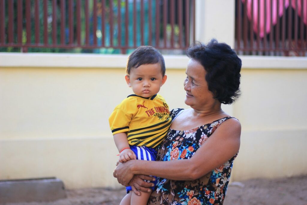 A grandmother holding her grandson outside