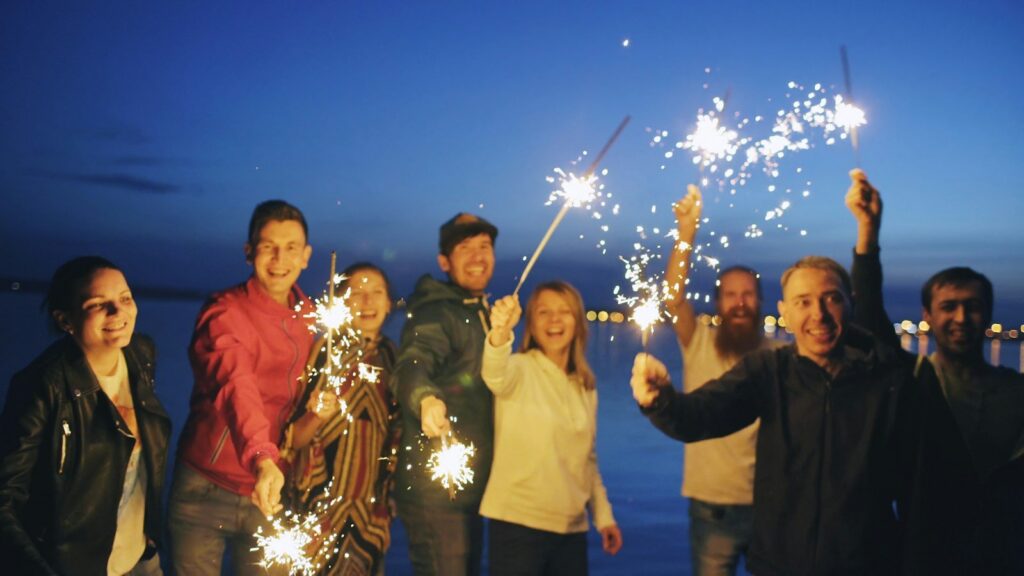 A family celebrating with sparklers at night