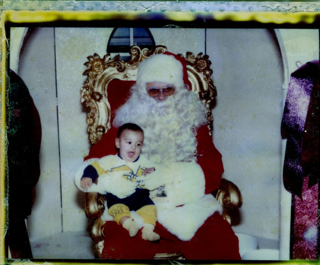 A baby smiling on Santa's lap