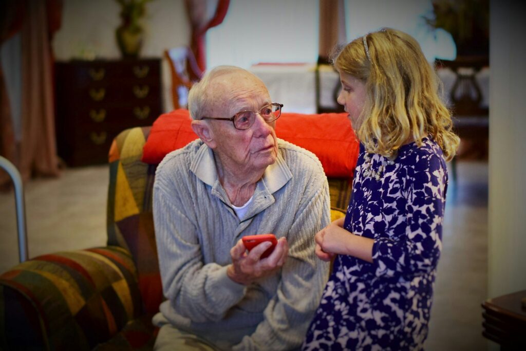 A grandfather chatting with his granddaughter at home