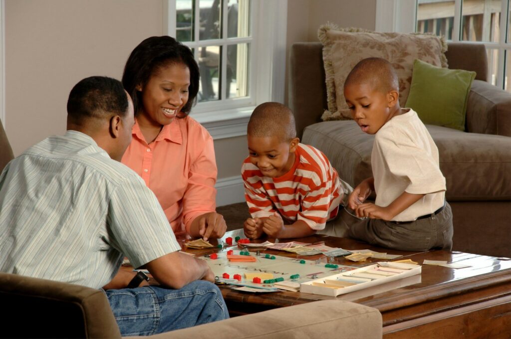 A family playing a board game together in the living room