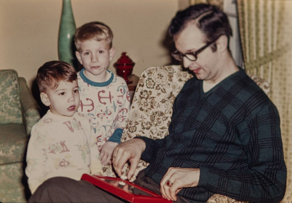 A 1970s snapshot of a father on the couch with his two sons