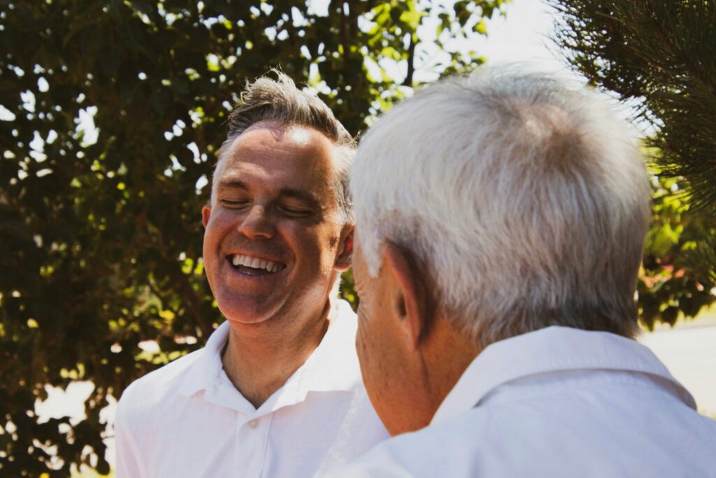A grown son laughing with his father